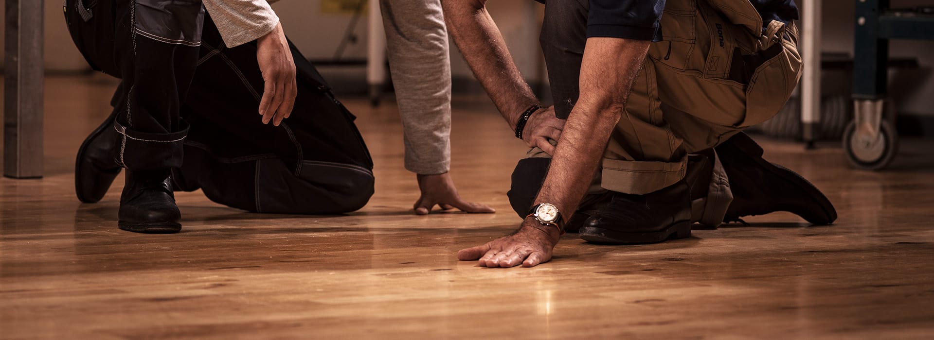 A Bona Certified Craftsman and client are kneeling on a gorgeous, newly refinished hardwood floor, reviewing details.