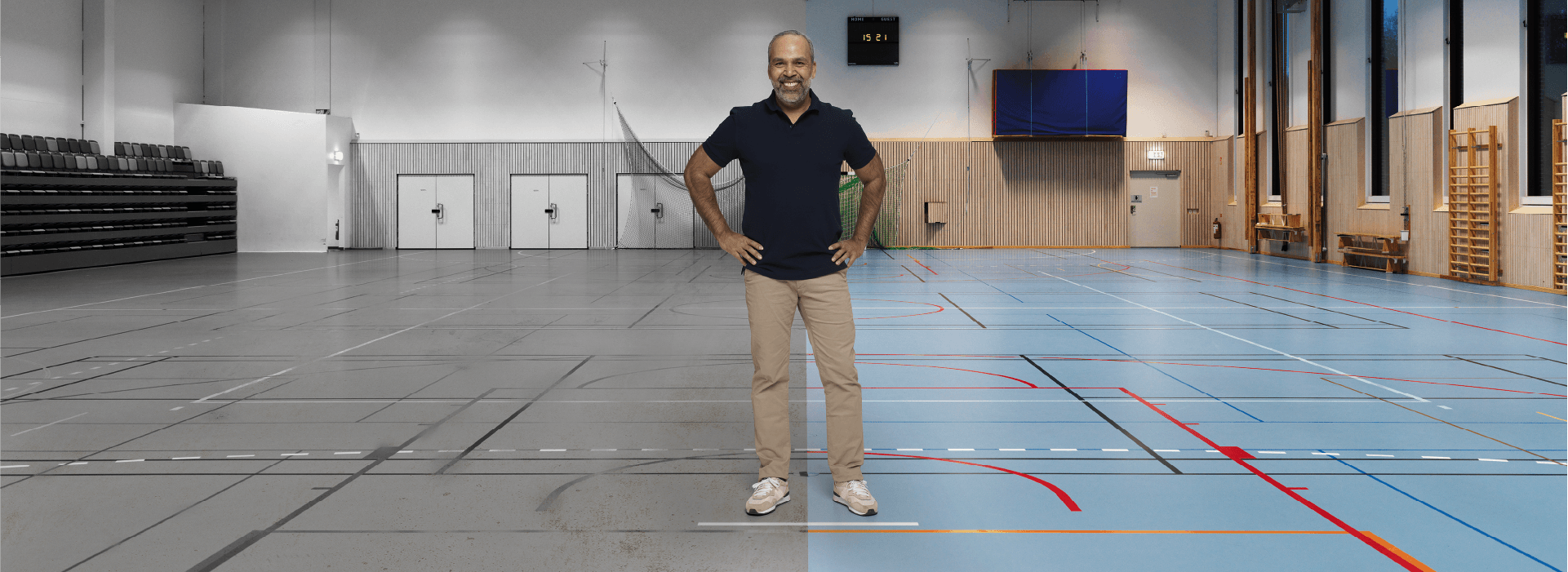 A smiling coach stands at center of a sport floor – old floor is to his right and renewed floor in color is to his left.