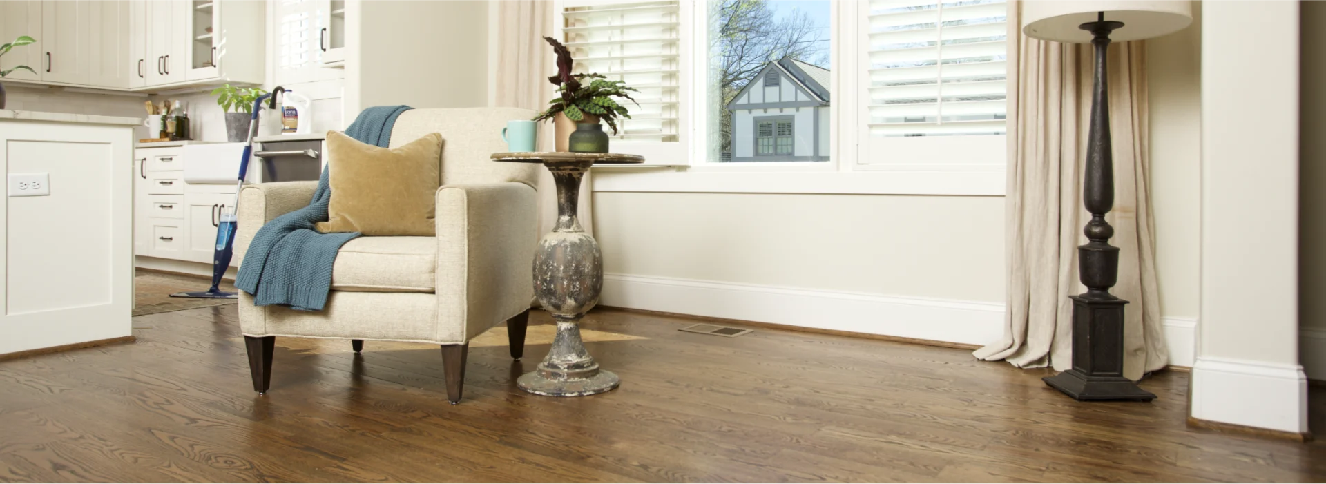 Lovely, traditional living room furniture on a spotlessly clean hardwood floor with a Bona Spray Mop in the background.
